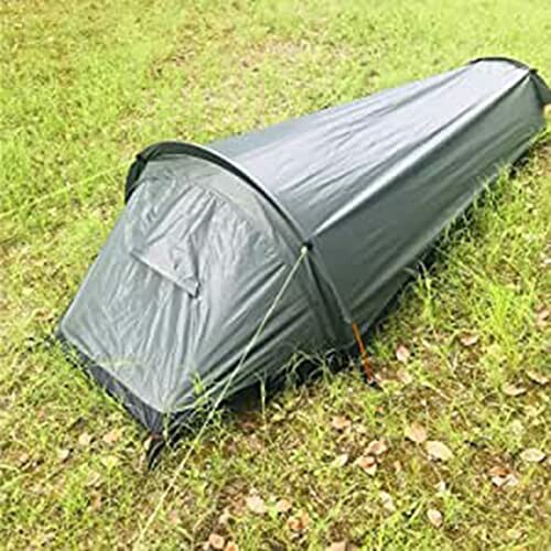 Small green camping tent on grass.