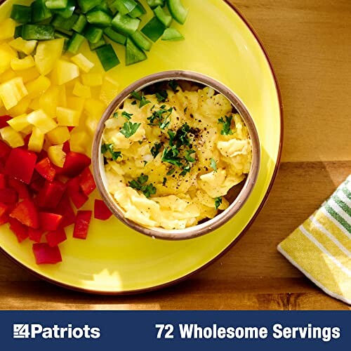 Plate of scrambled eggs surrounded by diced red, yellow, and green bell peppers.