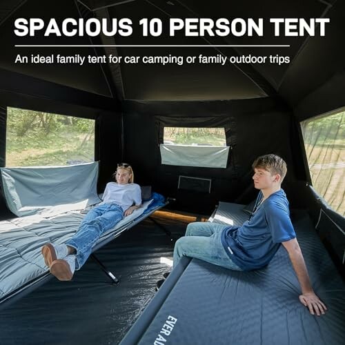 Two people relaxing inside a spacious 10-person tent with sleeping mats.