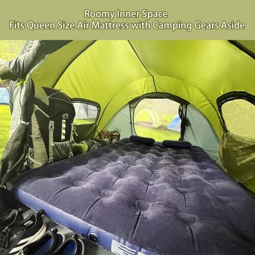 Interior of a spacious tent with a queen size air mattress and camping gear.